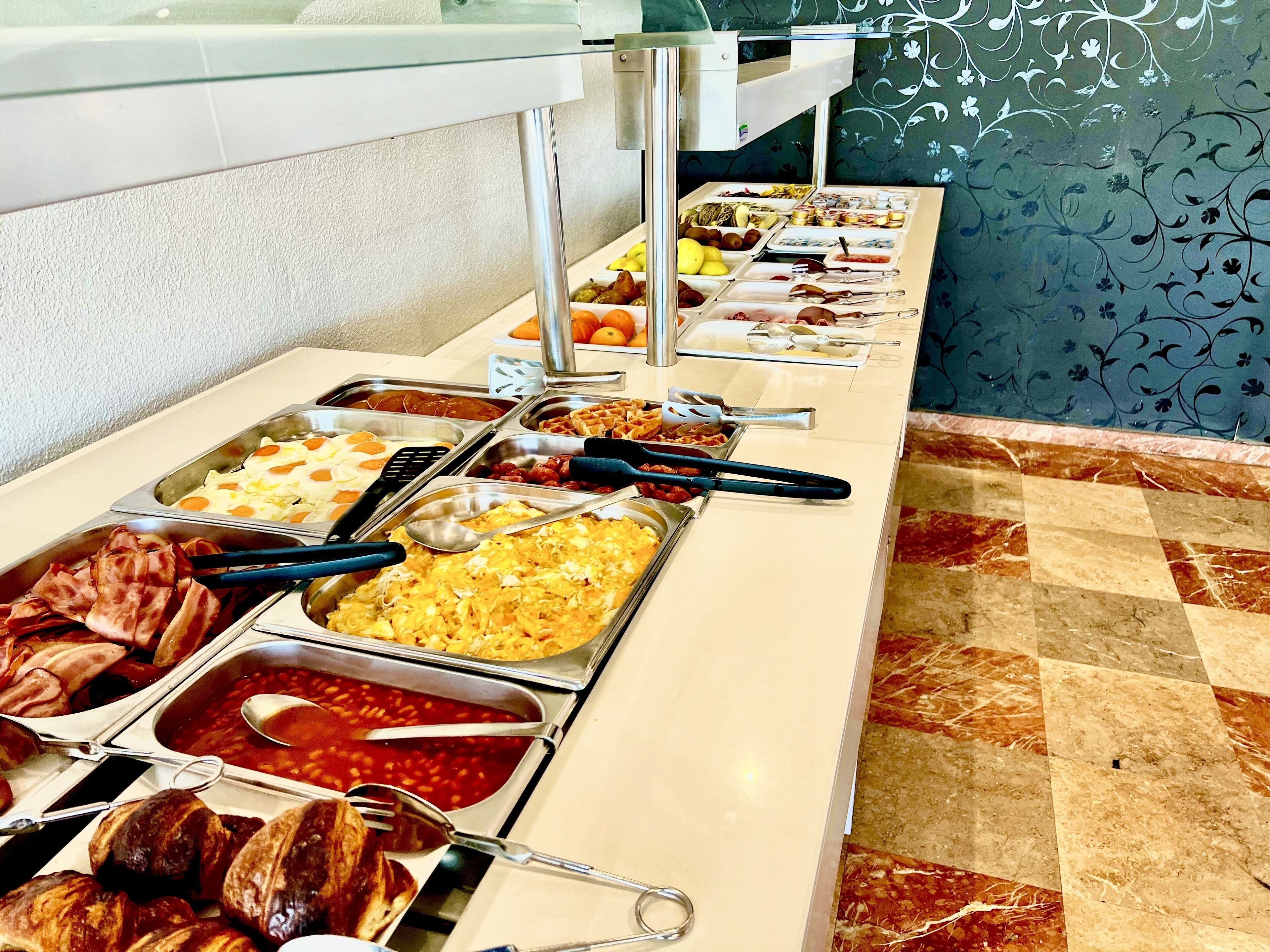 Un buffet proposant une variété de plats et d’ustensiles.
