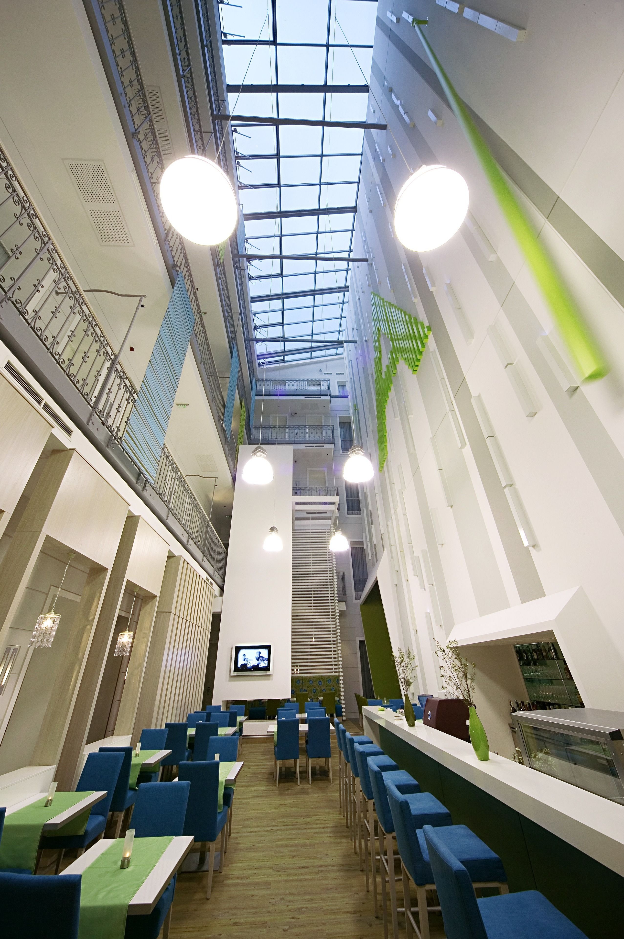 Un espace intérieur moderne doté d’un haut plafond, de plusieurs niveaux et d’un escalier central.