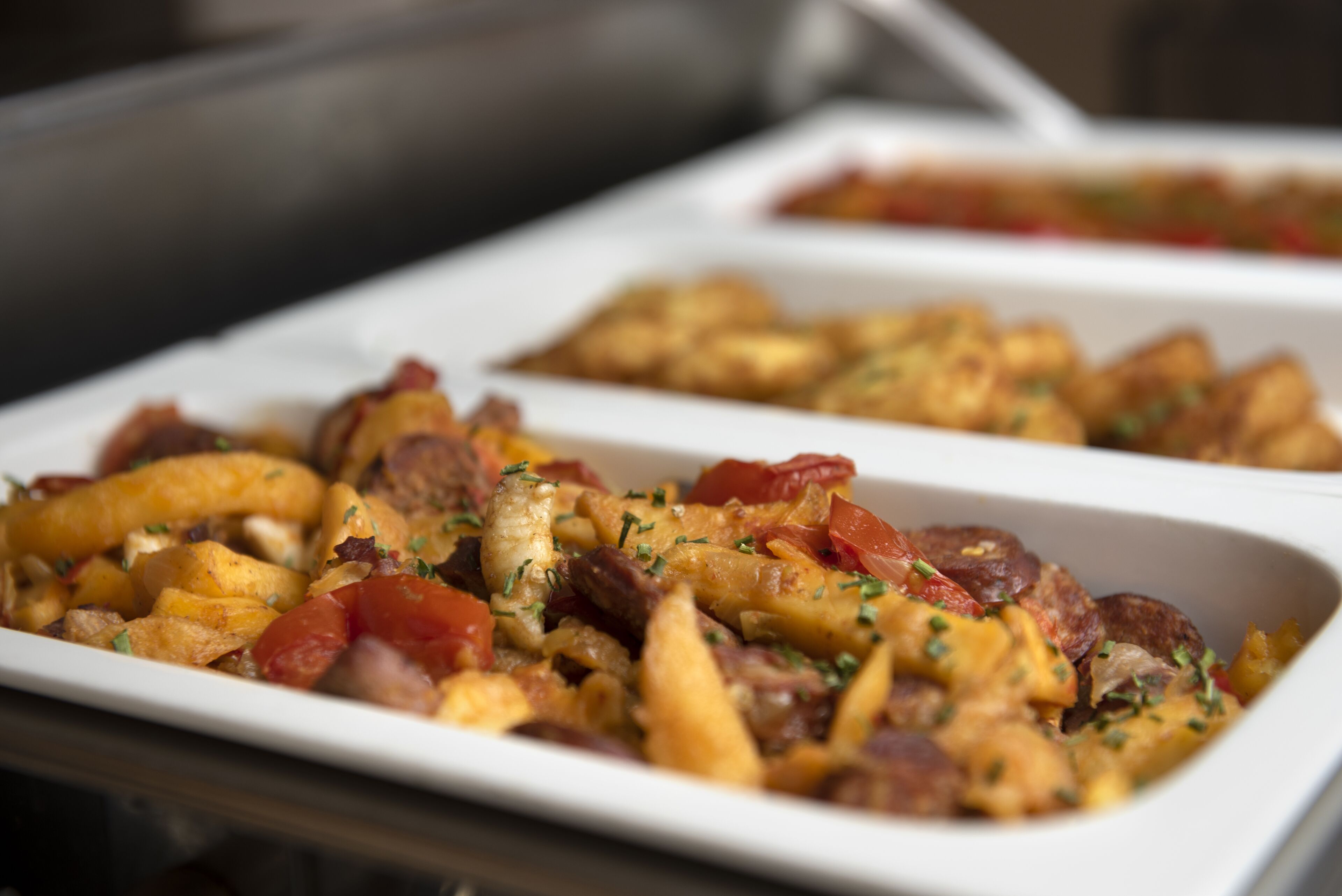 A dish with fries, meat, and vegetables in a white dish.