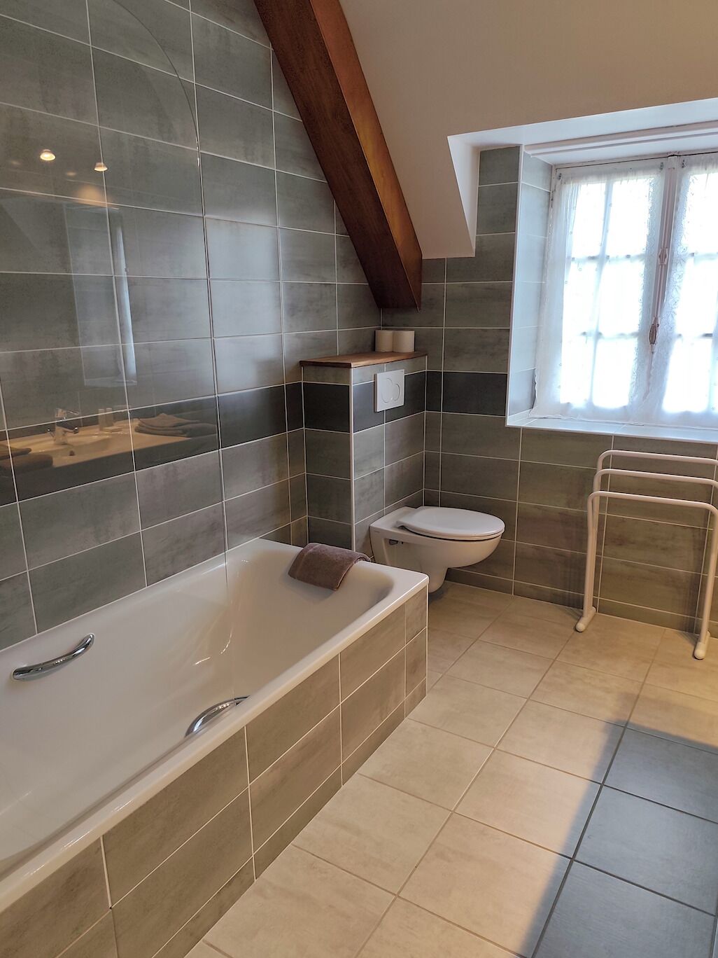 Un baño moderno con bañera, inodoro y ventana.
