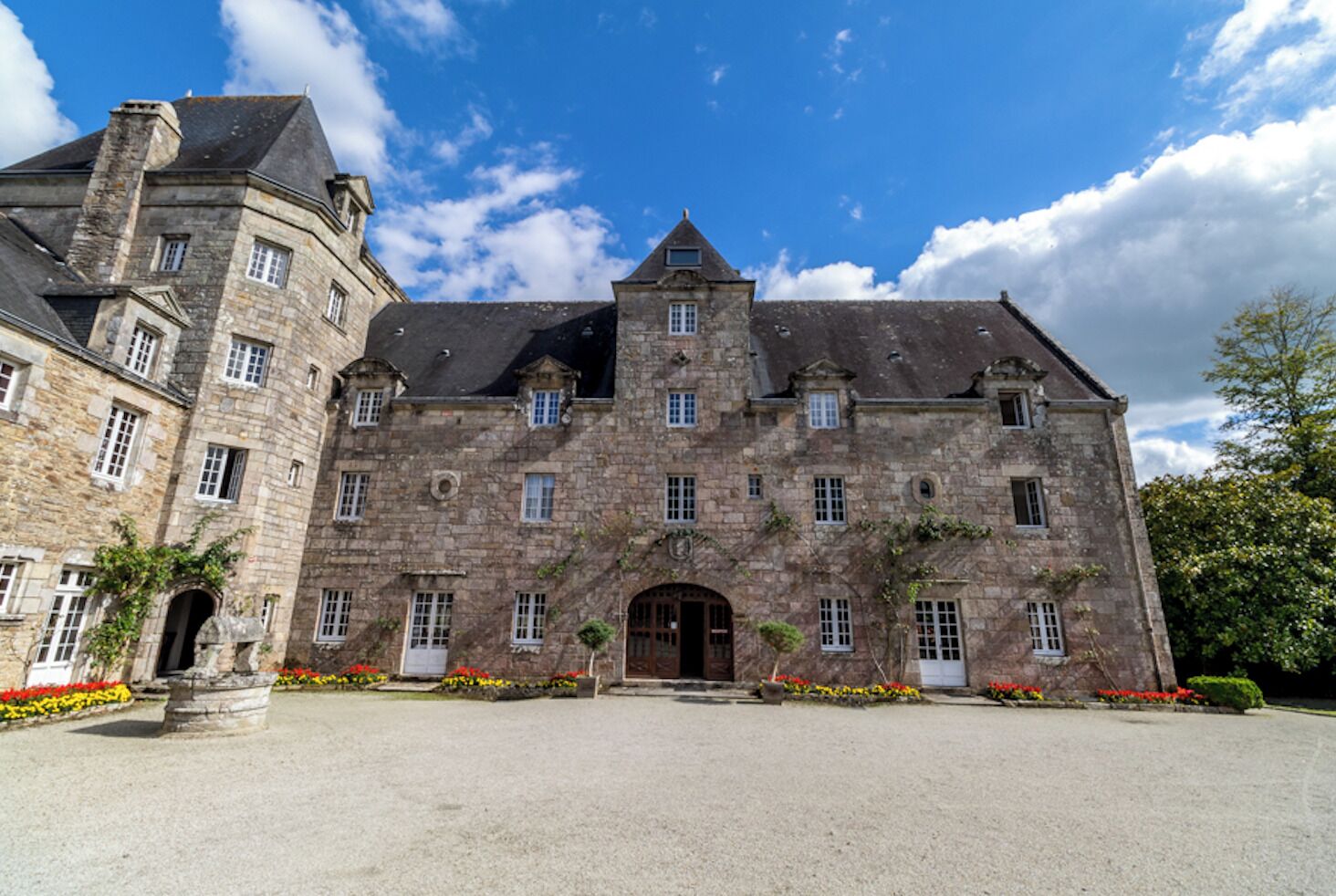 Ein großes Steinhaus mit vielen Fenstern und einem zentralen Eingang.