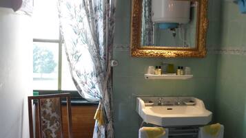 A bathroom with a sink, mirror, and chair.