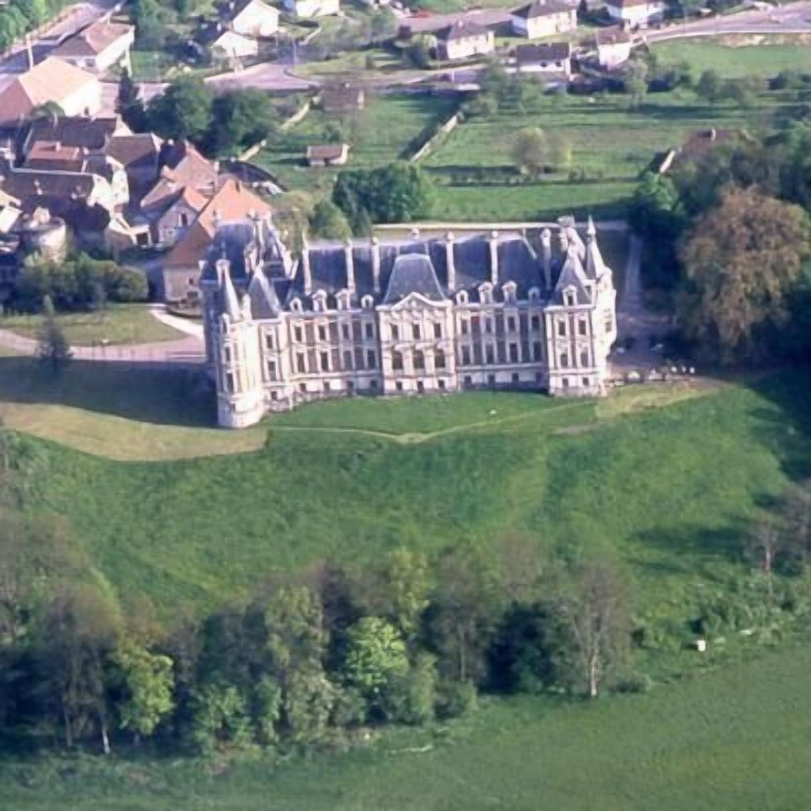 Un grand bâtiment historique à la façade symétrique, doté de nombreuses tours et d’une cour intérieure.