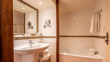 A bathroom with a sink, mirror, and bathtub.