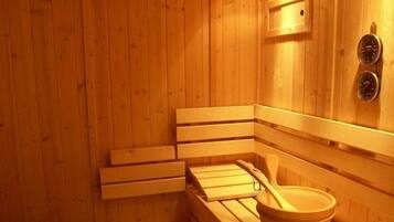 Una sauna de madera con bancos y una bañera de madera.