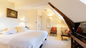 Une chambre à coucher avec un lit, une chaise, une télévision et un miroir.