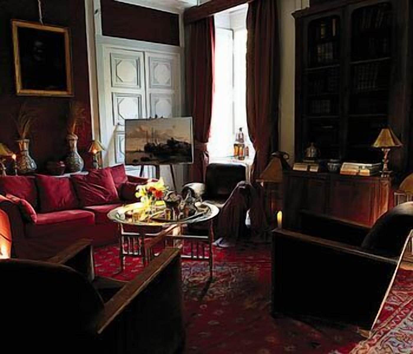 A cozy living room with a red sofa, a coffee table, and a bookshelf.