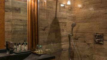 Une salle de bain moderne avec un mur en bois, un grand miroir et un espace douche.