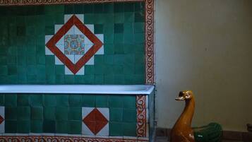 A tiled wall with a geometric pattern and a decorative swan statue.