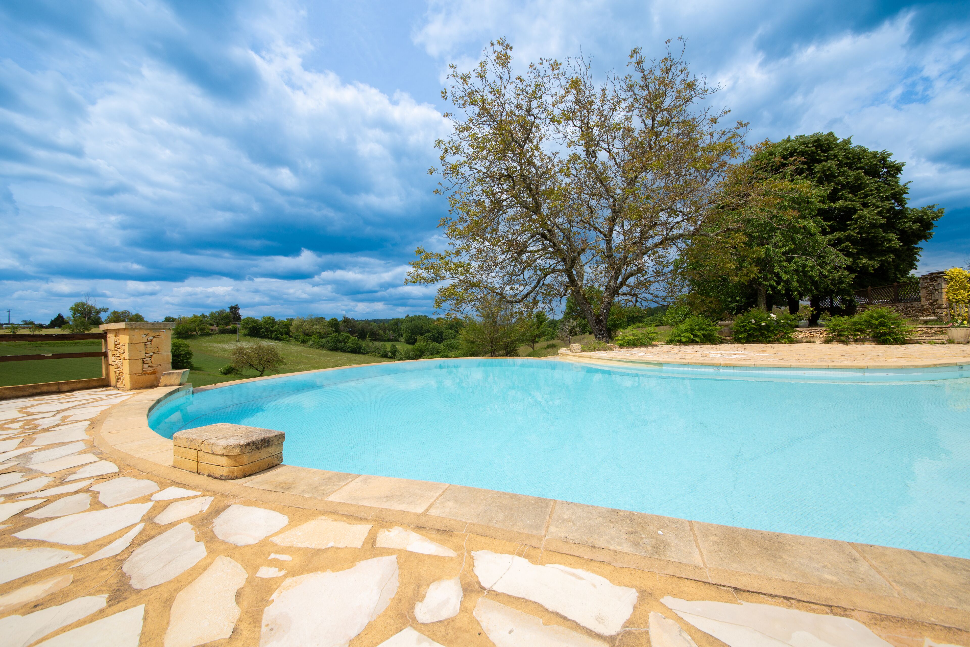 outdoor pool, an infinity pool, pool umbrellas, pool loungers
