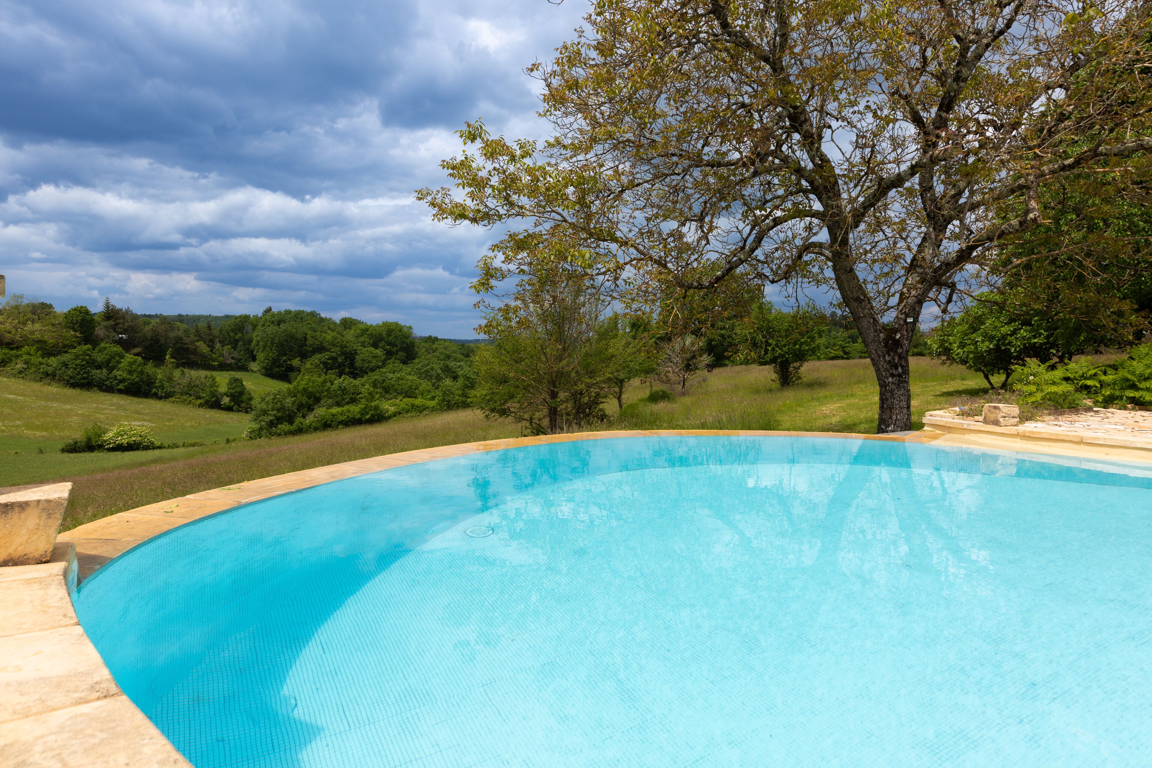 outdoor pool, an infinity pool, pool umbrellas, pool loungers