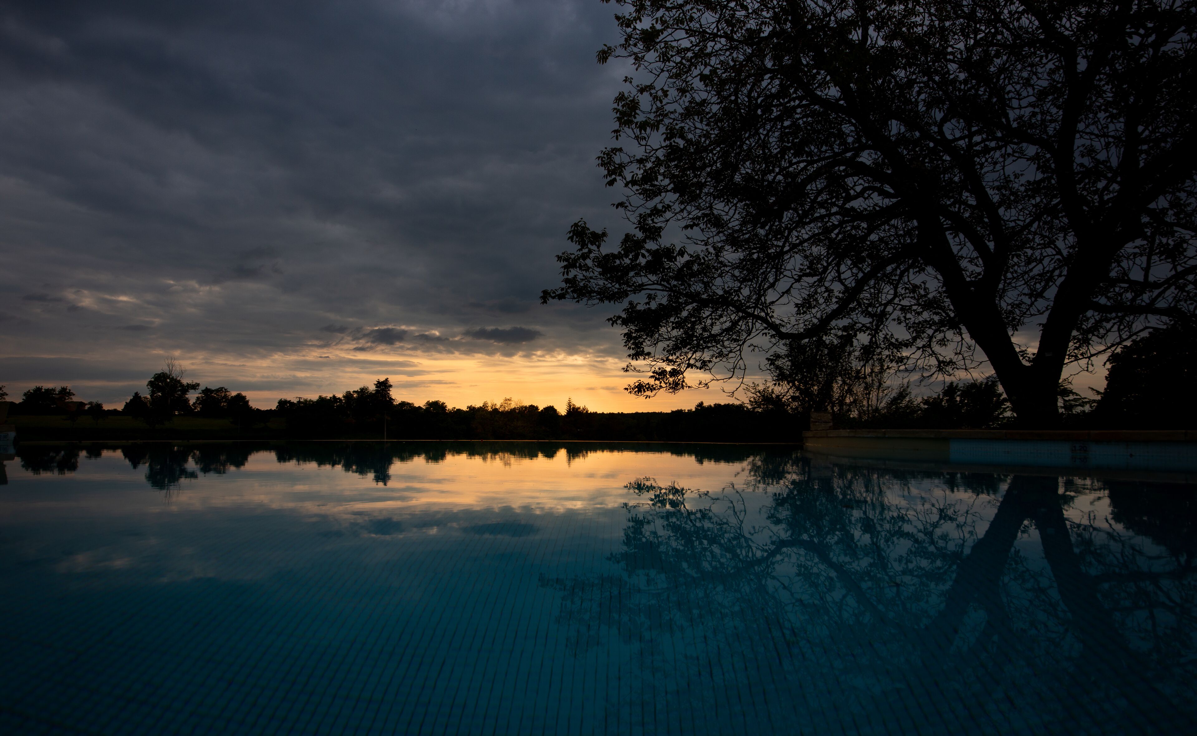outdoor pool, an infinity pool, pool umbrellas, pool loungers
