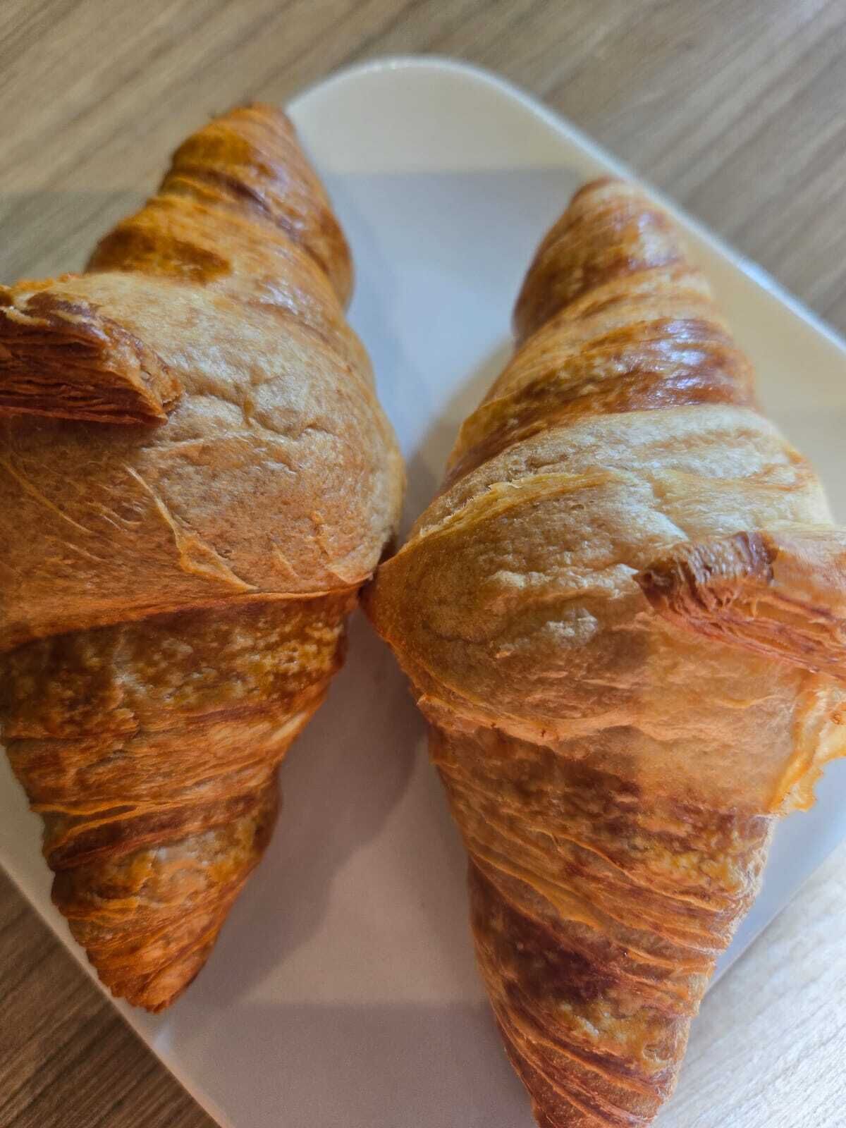 Two croissants on a white plate.