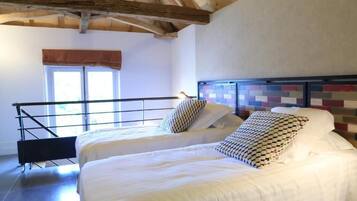 Un dormitorio con dos camas, una ventana con vistas y un techo de madera.