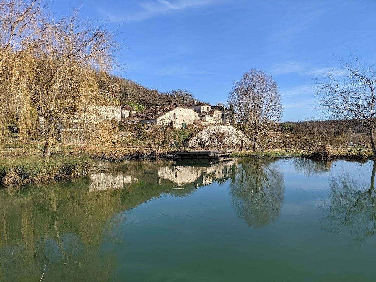 A serene riverside scene with a bridge and buildings reflecting on the water.