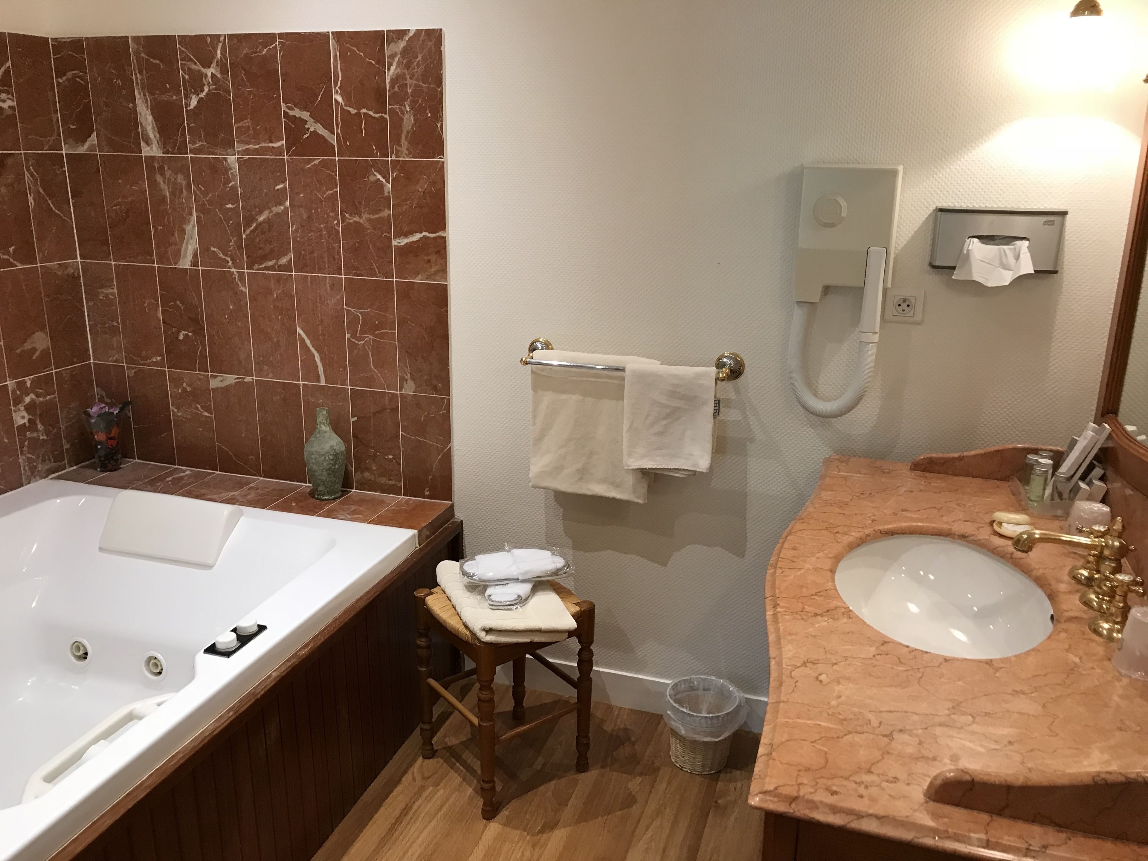 A bathroom with a bathtub, a sink, a towel rack, and a shower.