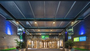 Entree van een Holiday Inn Express met een glazen deur, metalen frame en een bord erboven.