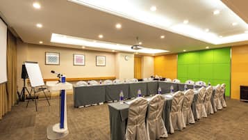 A conference room with a long table, chairs, a whiteboard, and a projector.