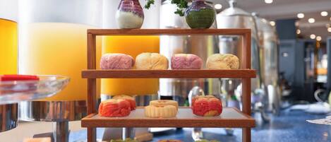 A buffet with various pastries and a vase with flowers.
