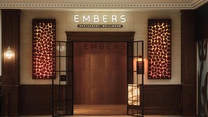 A building entrance with a sign reading 'EMBERS RESTAURANT - GRILLROOM' and a decorative wall with a pattern.