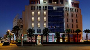 Un hôtel doté d’une façade moderne, de nombreux balcons et d’une enseigne bien visible.