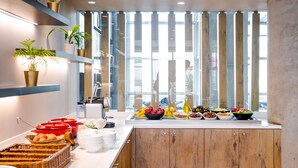 Une cuisine moderne avec des meubles en bois, un plan de travail blanc et divers produits alimentaires exposés.