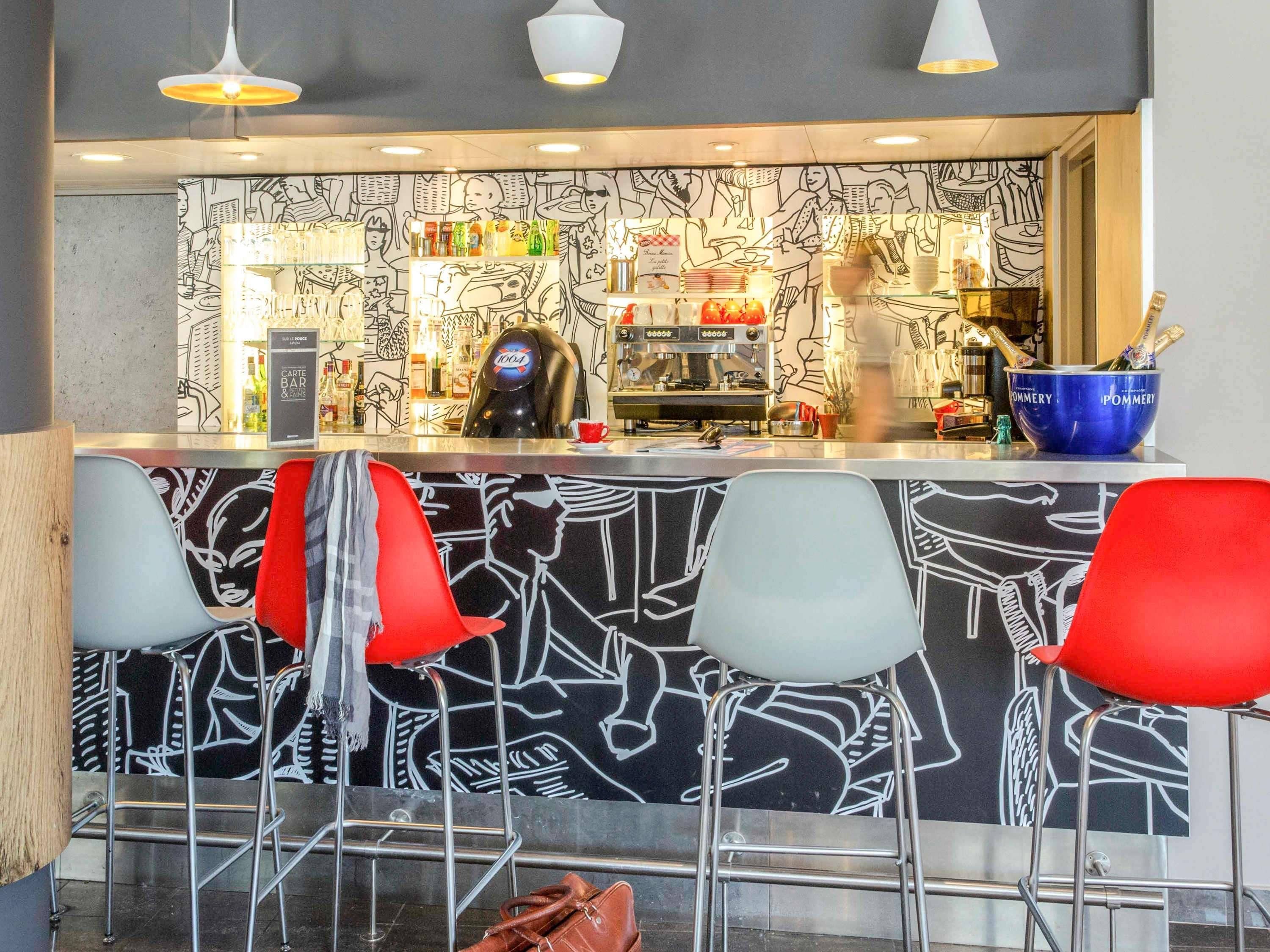 Eine Bar mit Theke, Hockern und Wandgemälde.
