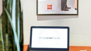 A computer monitor displaying "ENFACE VERBINDUNG" on a desk with a keyboard, mouse, and a mug.