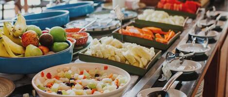 A buffet with various food items and utensils.
