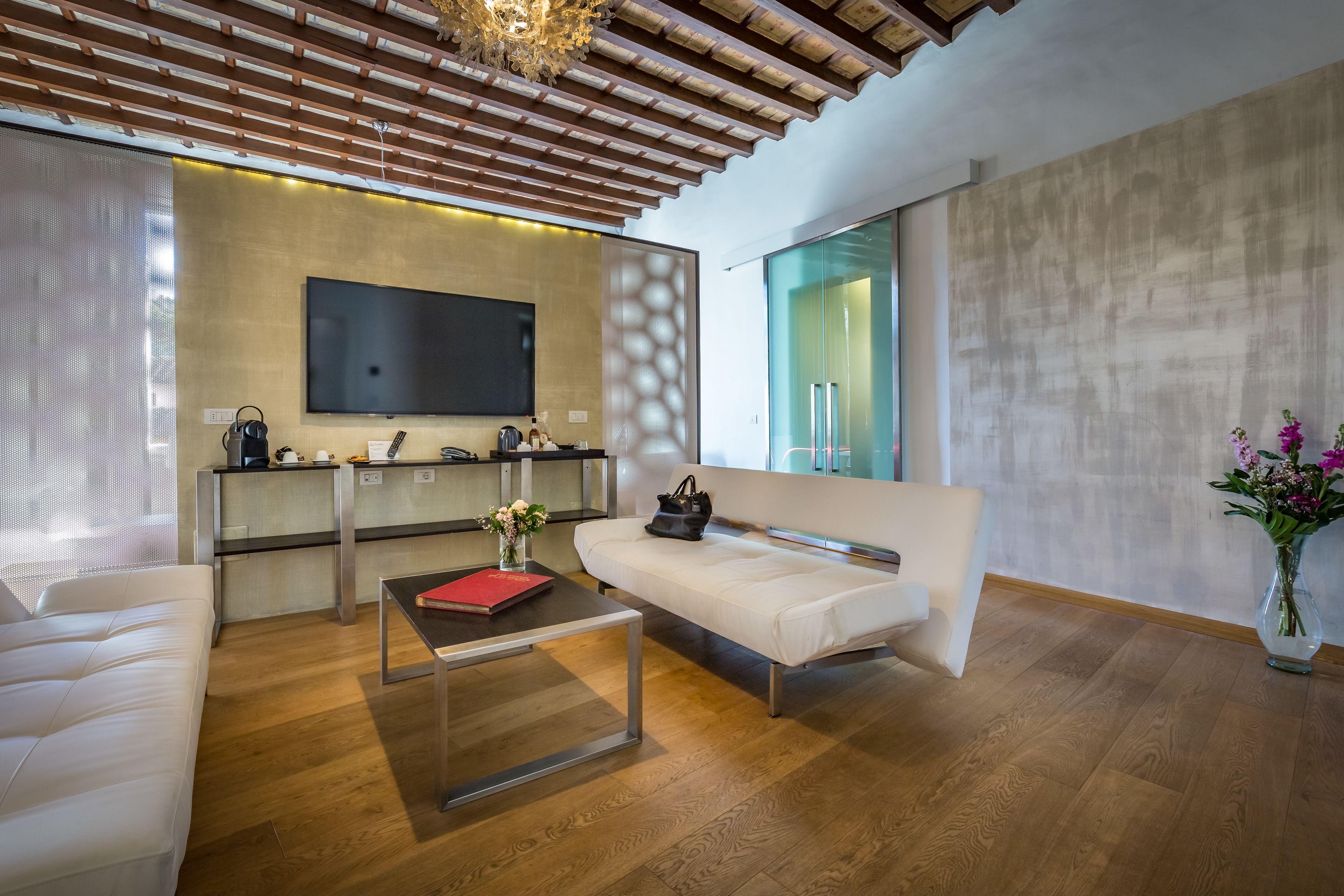Una sala de estar moderna con un sofá, una mesa de centro y un televisor de pantalla plana montado en la pared.