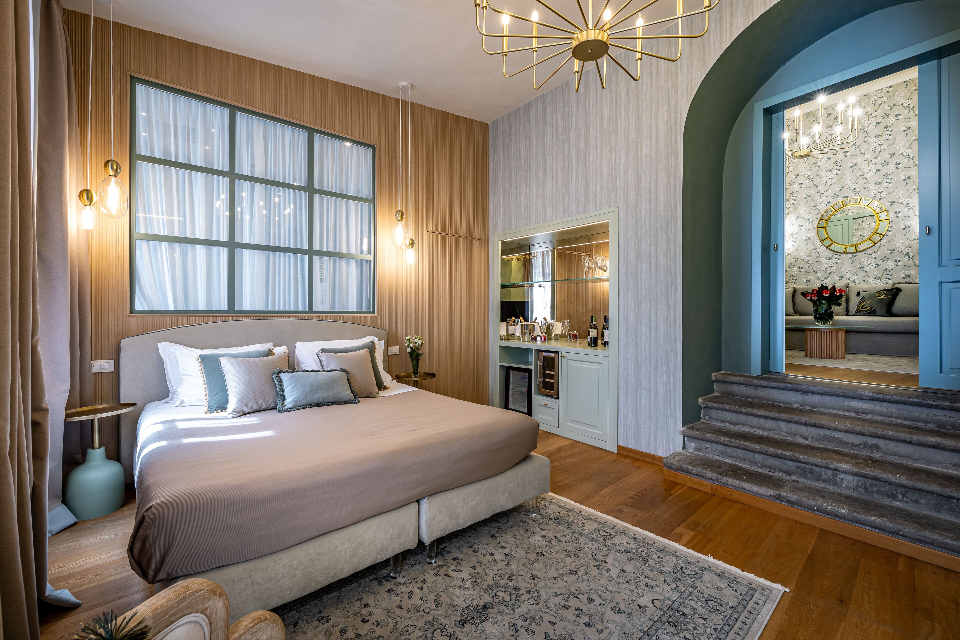 Un dormitorio moderno con una cama grande, un vestidor y una escalera que sube a un piso superior.