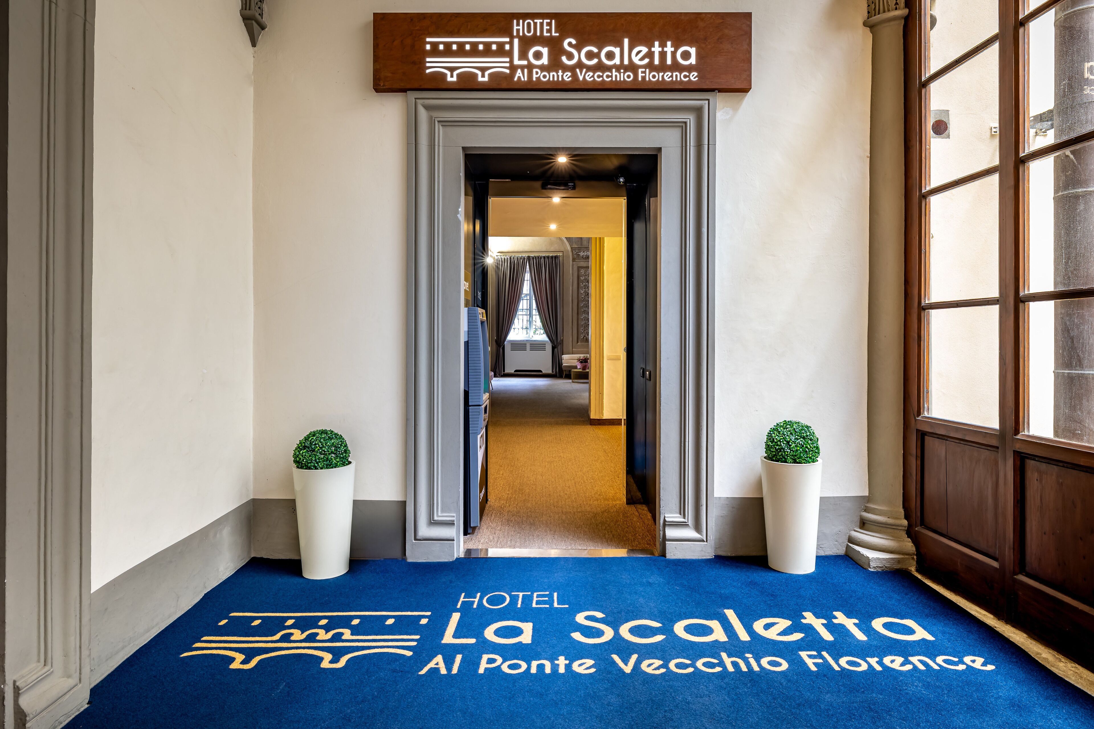 A hotel entrance with a sign reading "HOTEL La Scaletta Al Ponte Vecchio Florence".