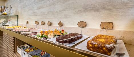 A buffet with various food items and a wooden wall in the background.