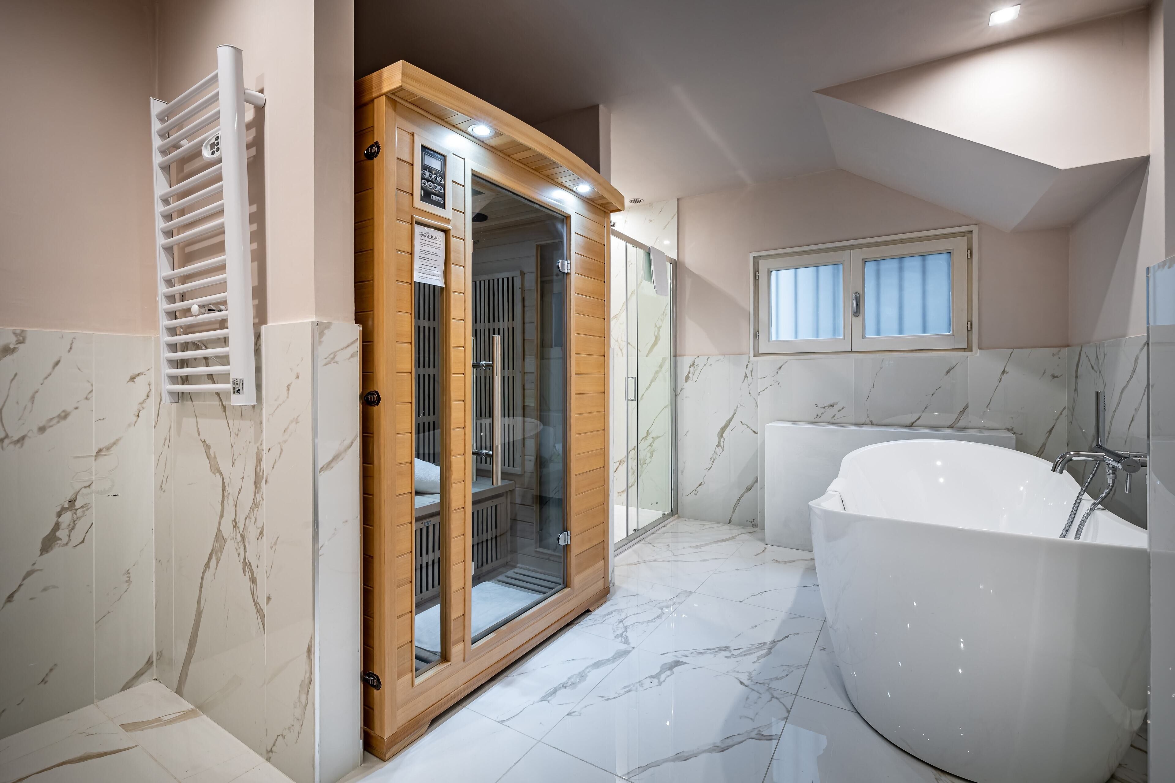 Une salle de bain moderne avec une grande baignoire, une douche à l’italienne et un meuble-lavabo en bois.