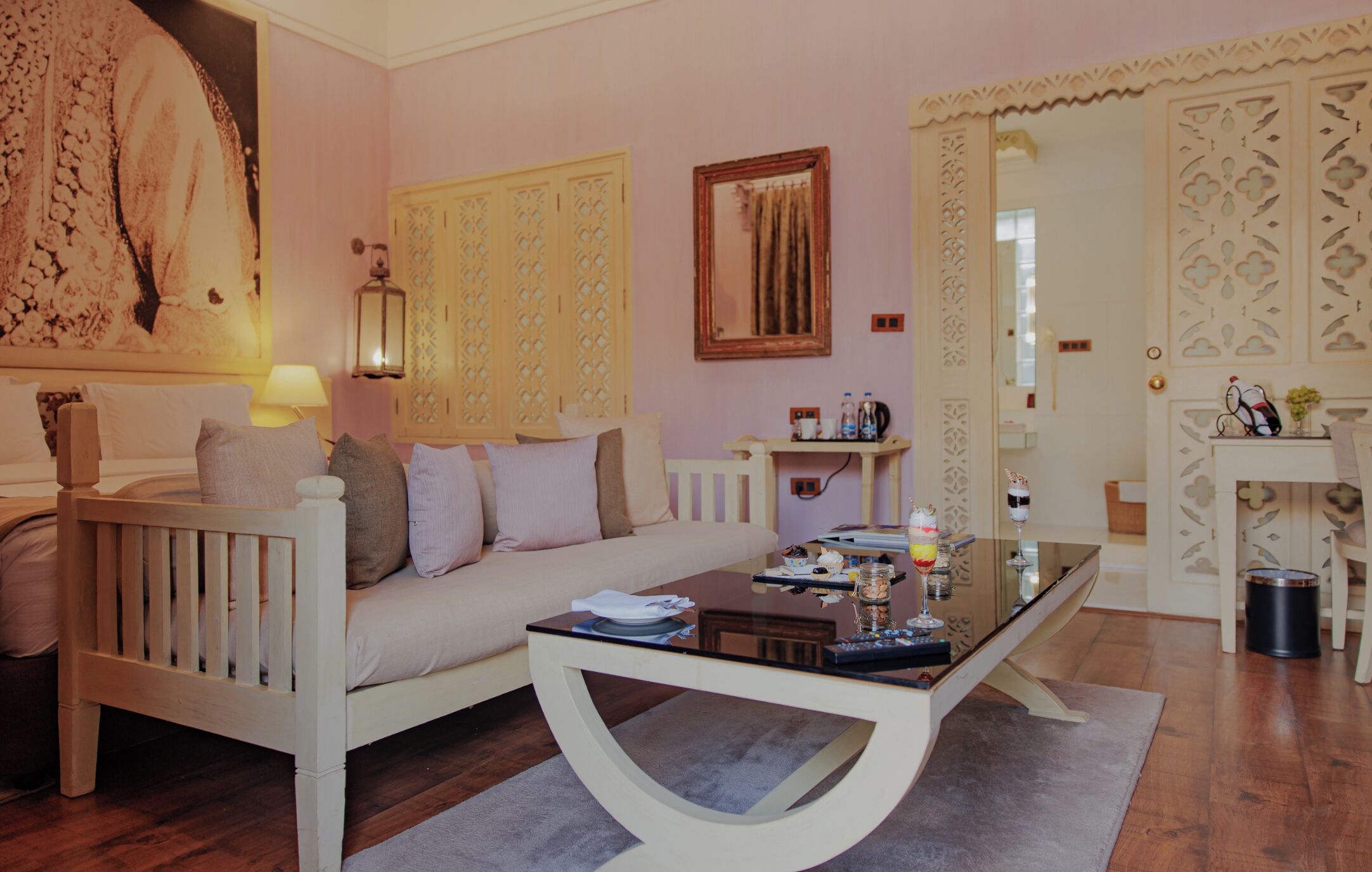 A living room with a sofa, a coffee table, a lamp, and a painting on the wall.