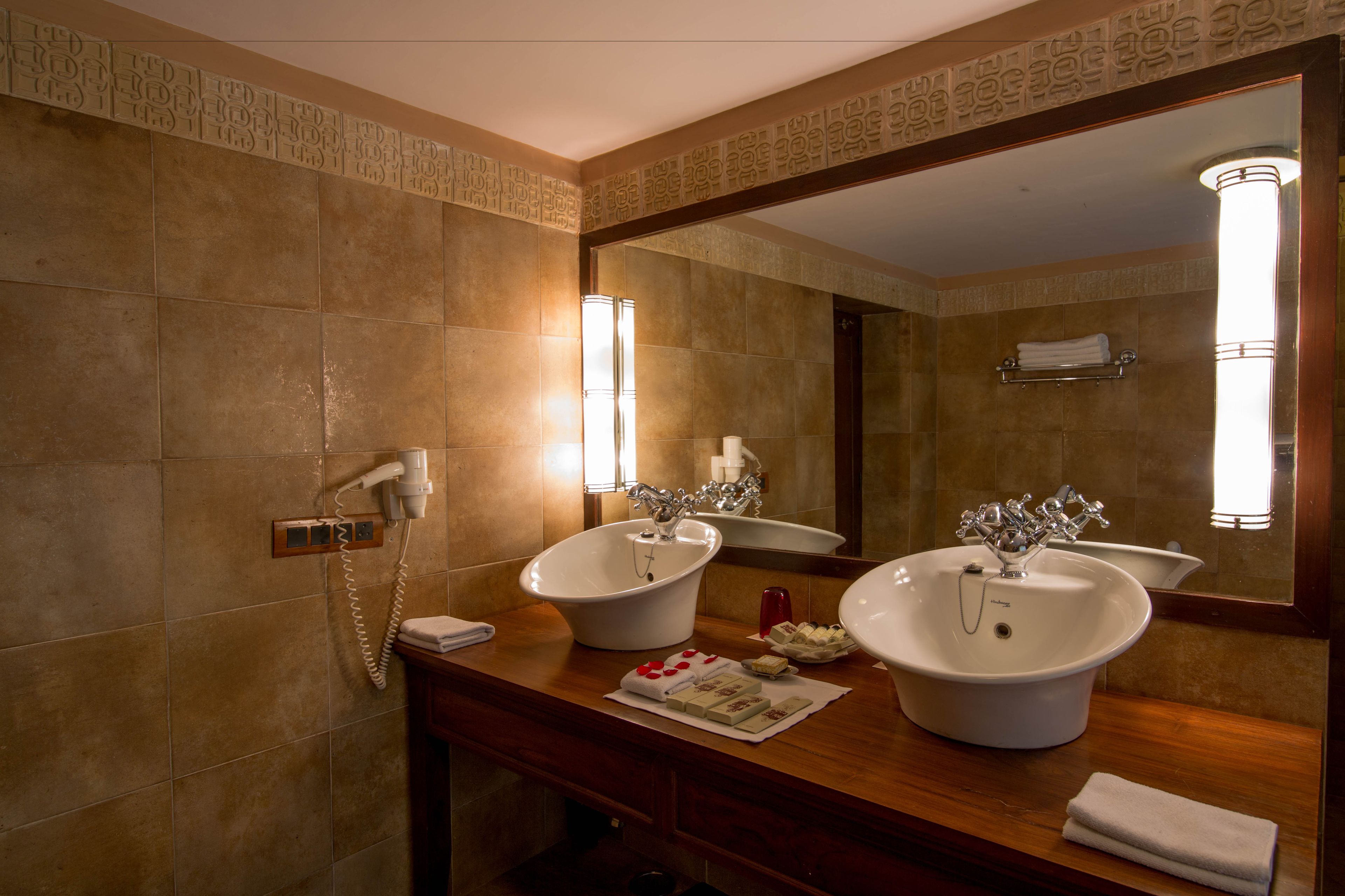 A bathroom with two sinks, a mirror, and a towel rack.