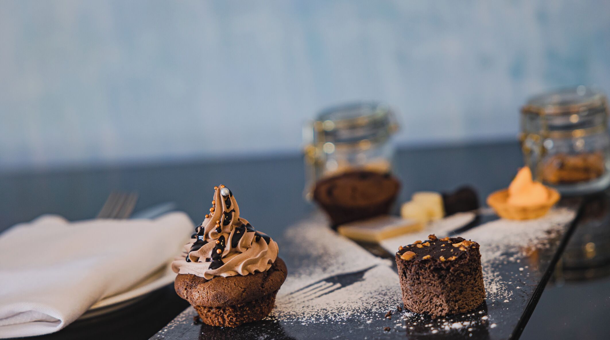 Un tavolo con dolci assortiti e un barattolo di vetro.
