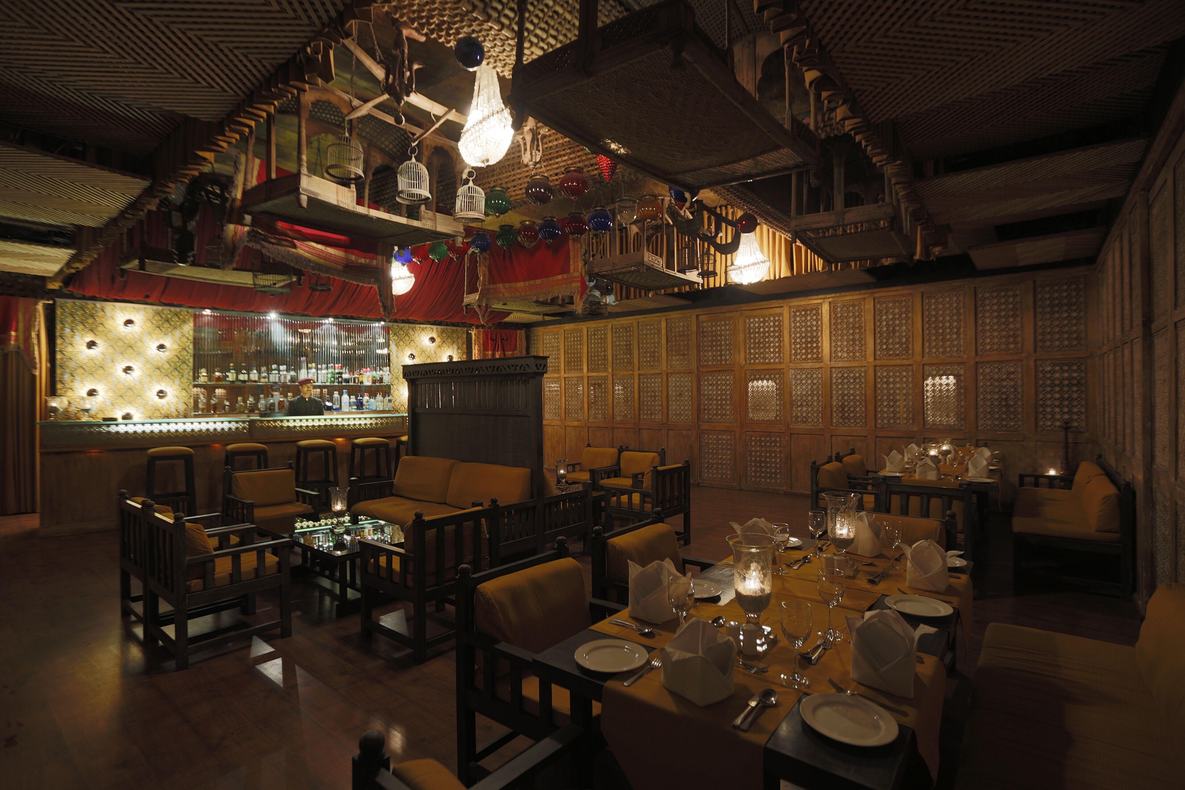 Un restaurant à la lumière tamisée, doté de meubles en bois, d’un bar et d’une décoration traditionnelle.