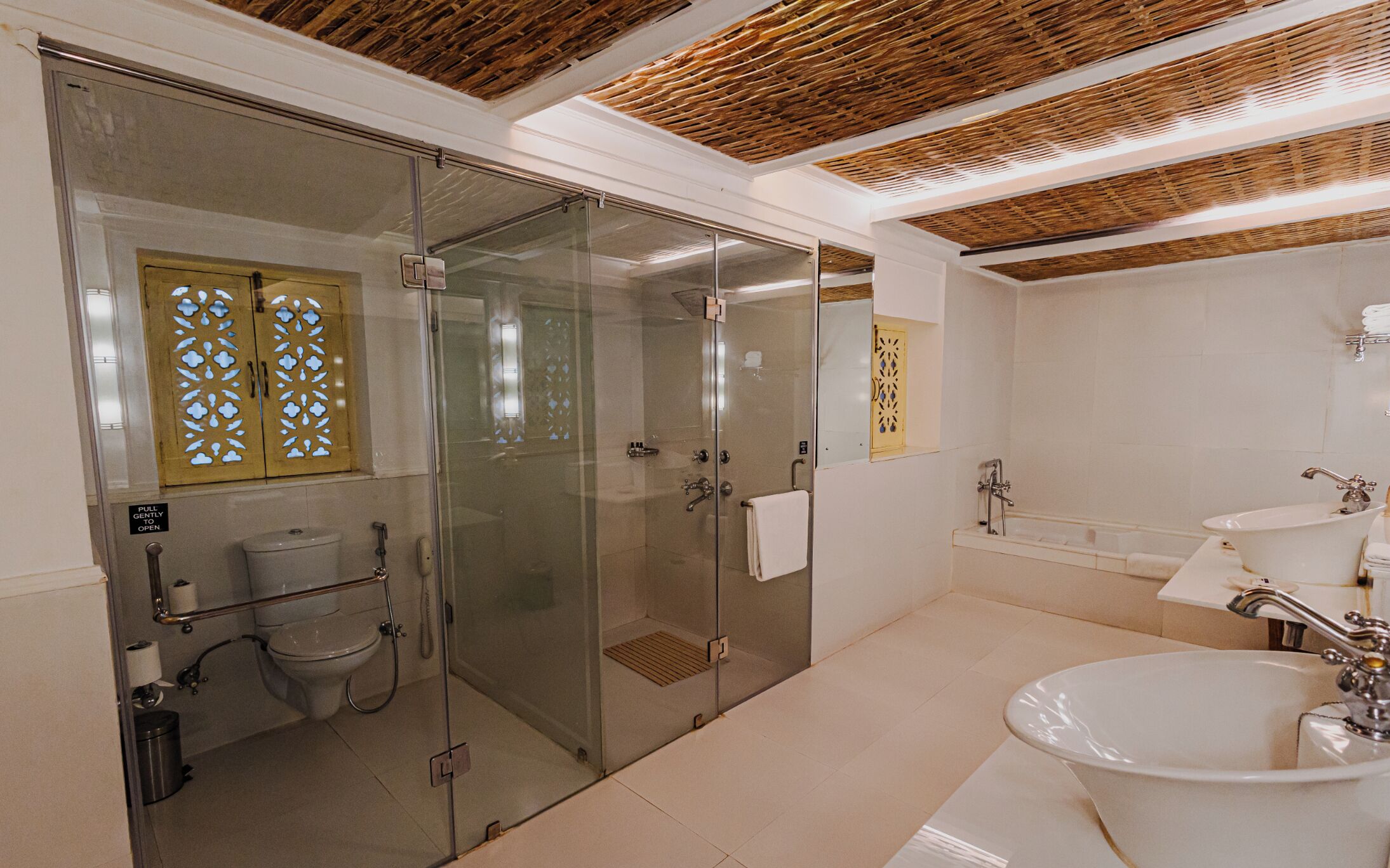 A modern bathroom with a glass-enclosed shower, a white sink, and a bathtub.