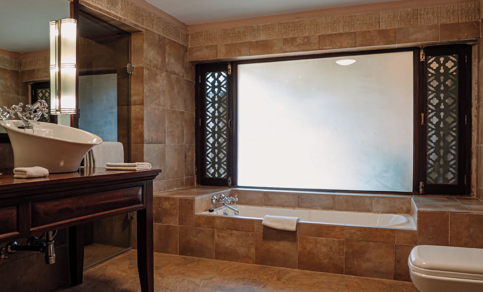A bathroom with a freestanding bathtub, a vanity with a mirror, and a toilet.