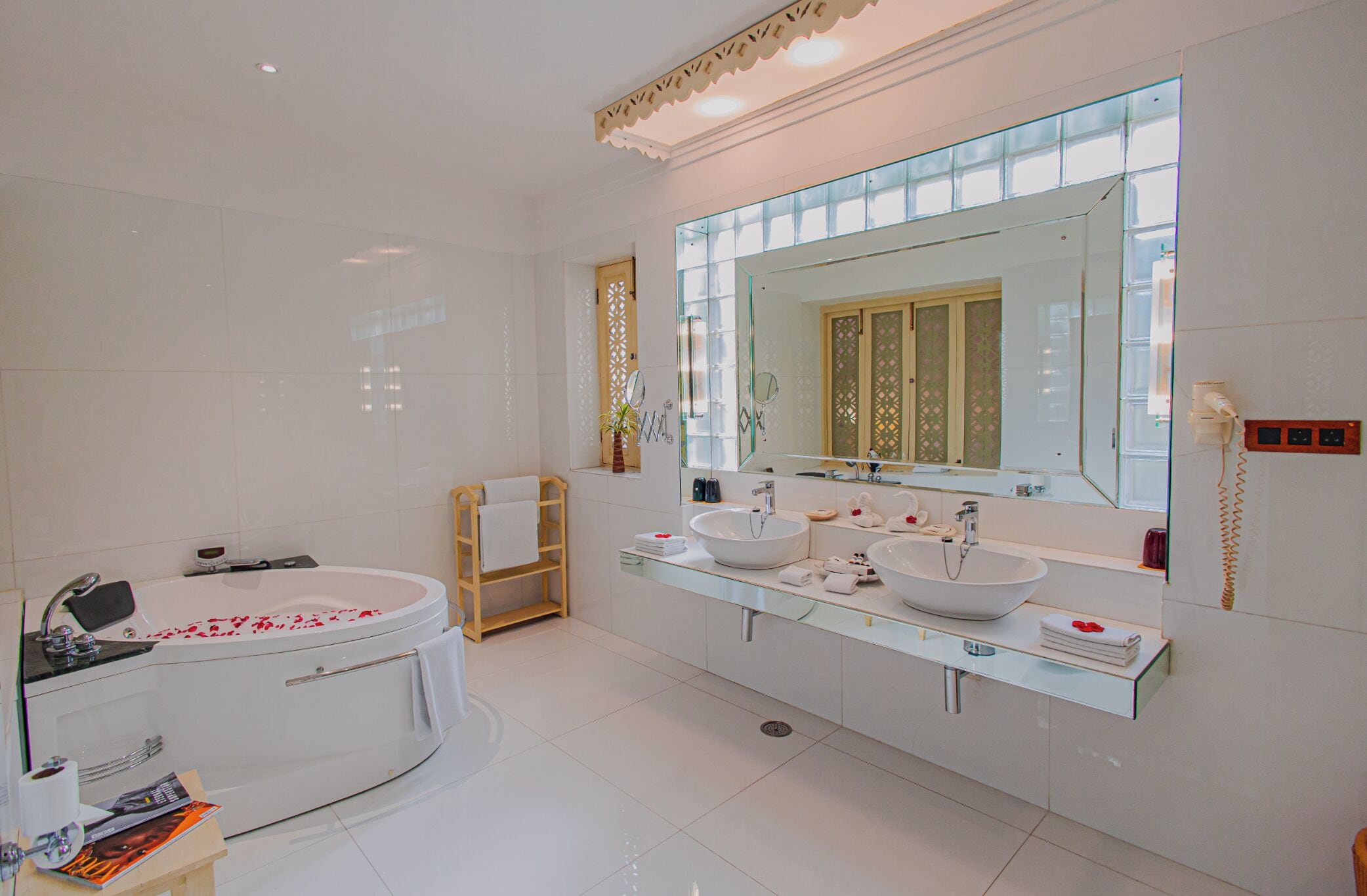 Een moderne badkamer met een groot bad, twee wasbakken en een grote spiegel.