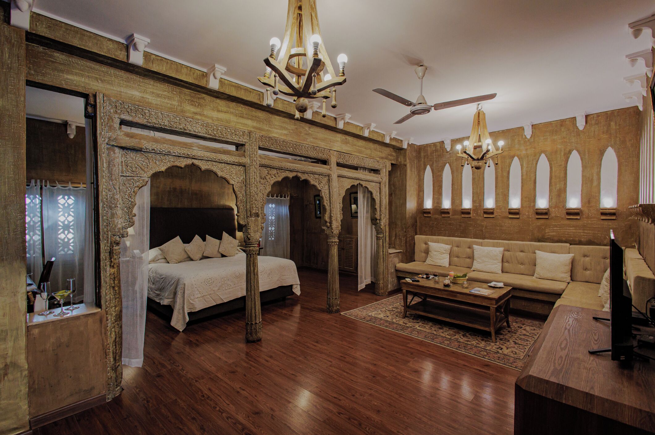 Una habitación con cama, sofá y ventilador de techo.