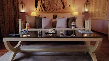 Une pièce comprenant un canapé, une table basse et deux lampes fixées au mur.