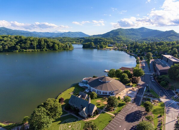Vue aérienne d’une propriété au bord du lac, avec une grande maison, un belvédère et un parking.
