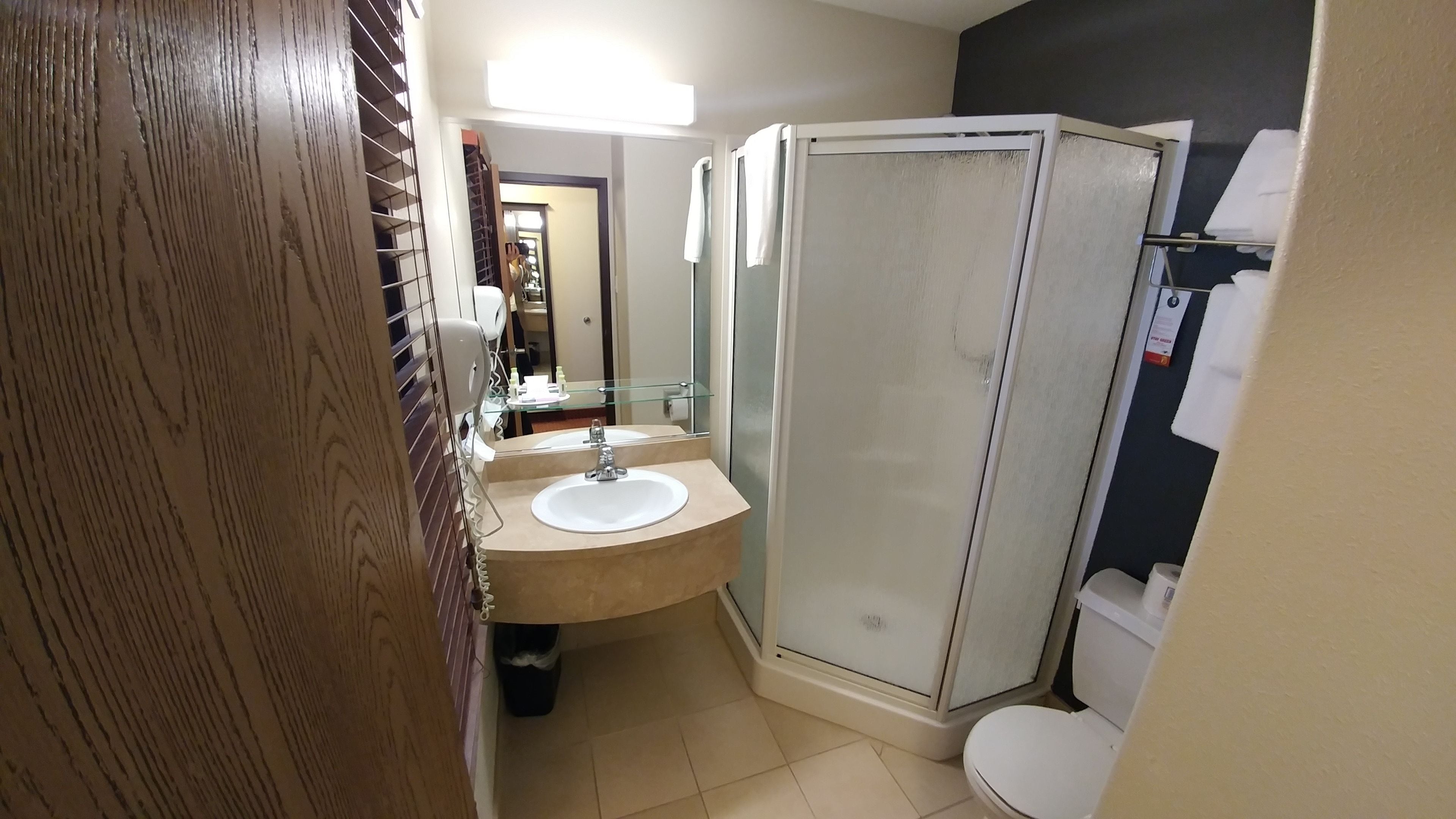 A bathroom with a shower, toilet, and sink.