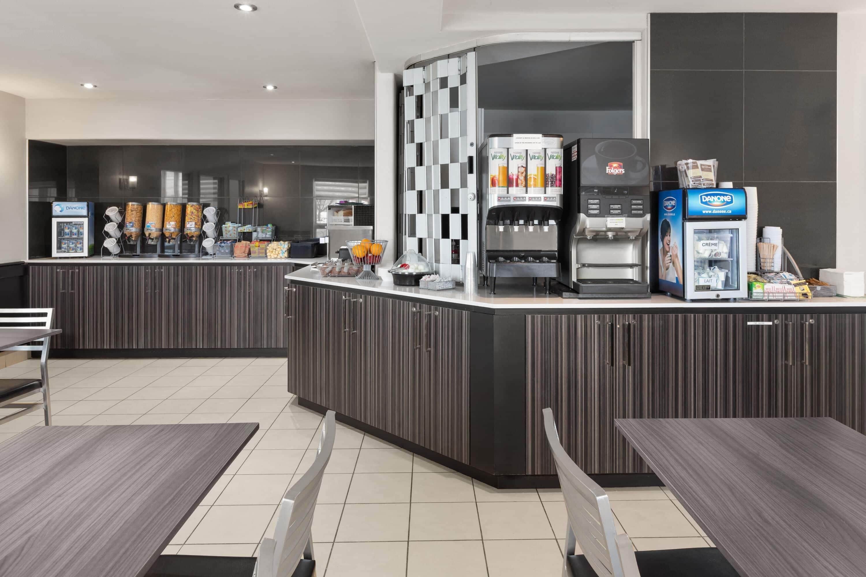 Un moderno vestíbulo de hotel con un mostrador central, zona de estar y una estación de café.