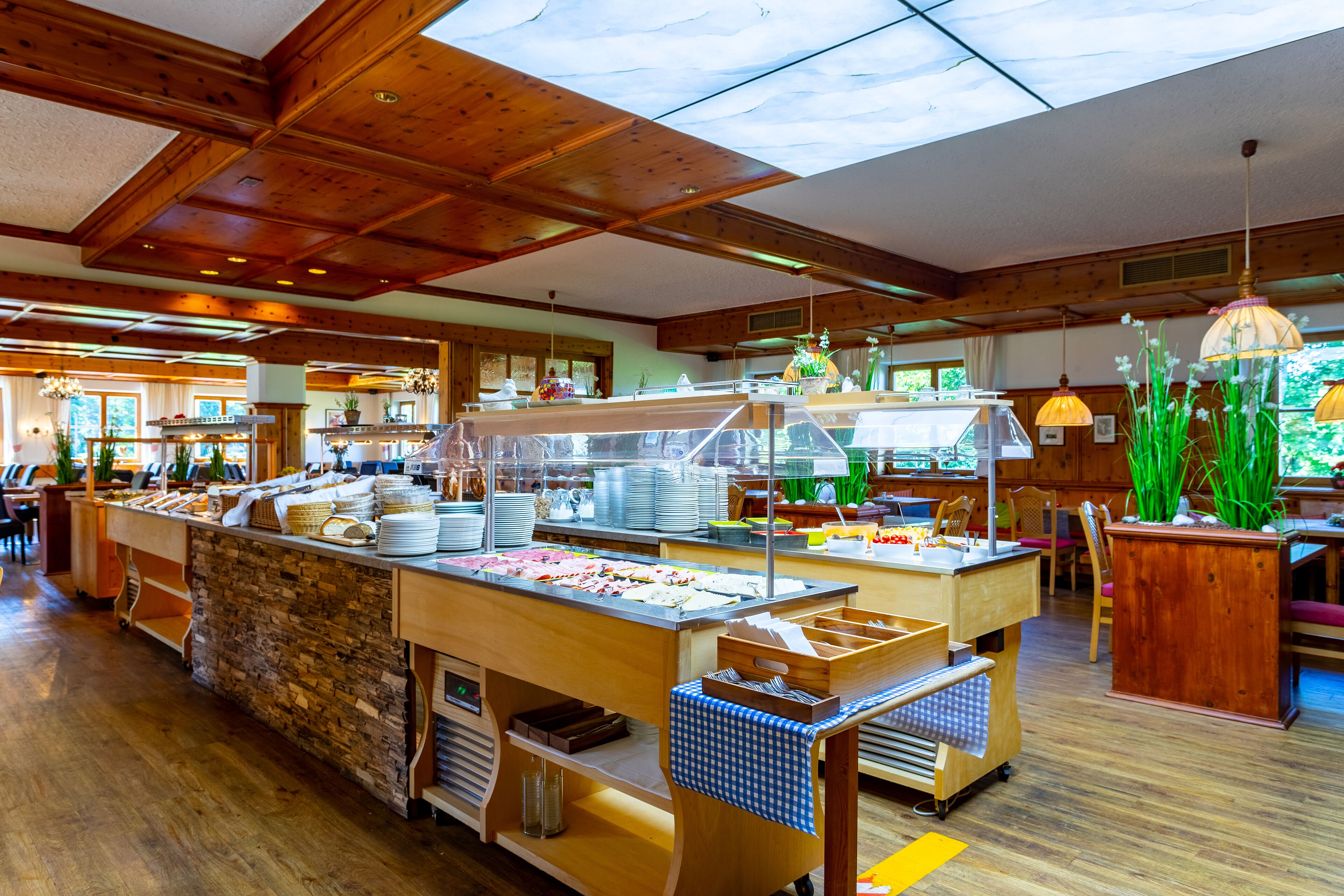 Montaje de buffet con diversos alimentos y un muro de piedra de fondo.