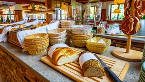 A buffet area with various breads and baskets on a counter. - Das Wiesgauer - Alpenhotel Inzell (Inzell)
