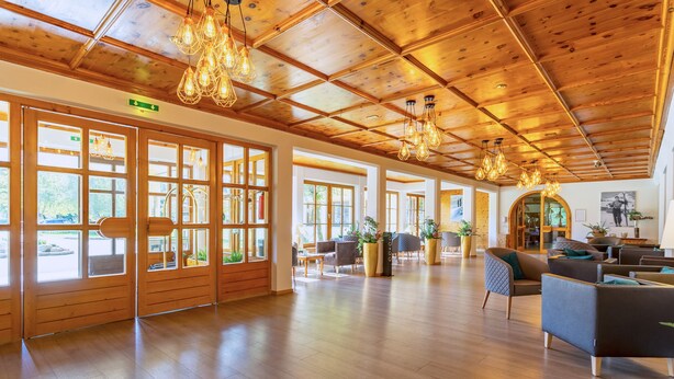 A spacious lobby with wooden floors, large windows, and modern lighting fixtures. - Das Wiesgauer - Alpenhotel Inzell (Inzell)