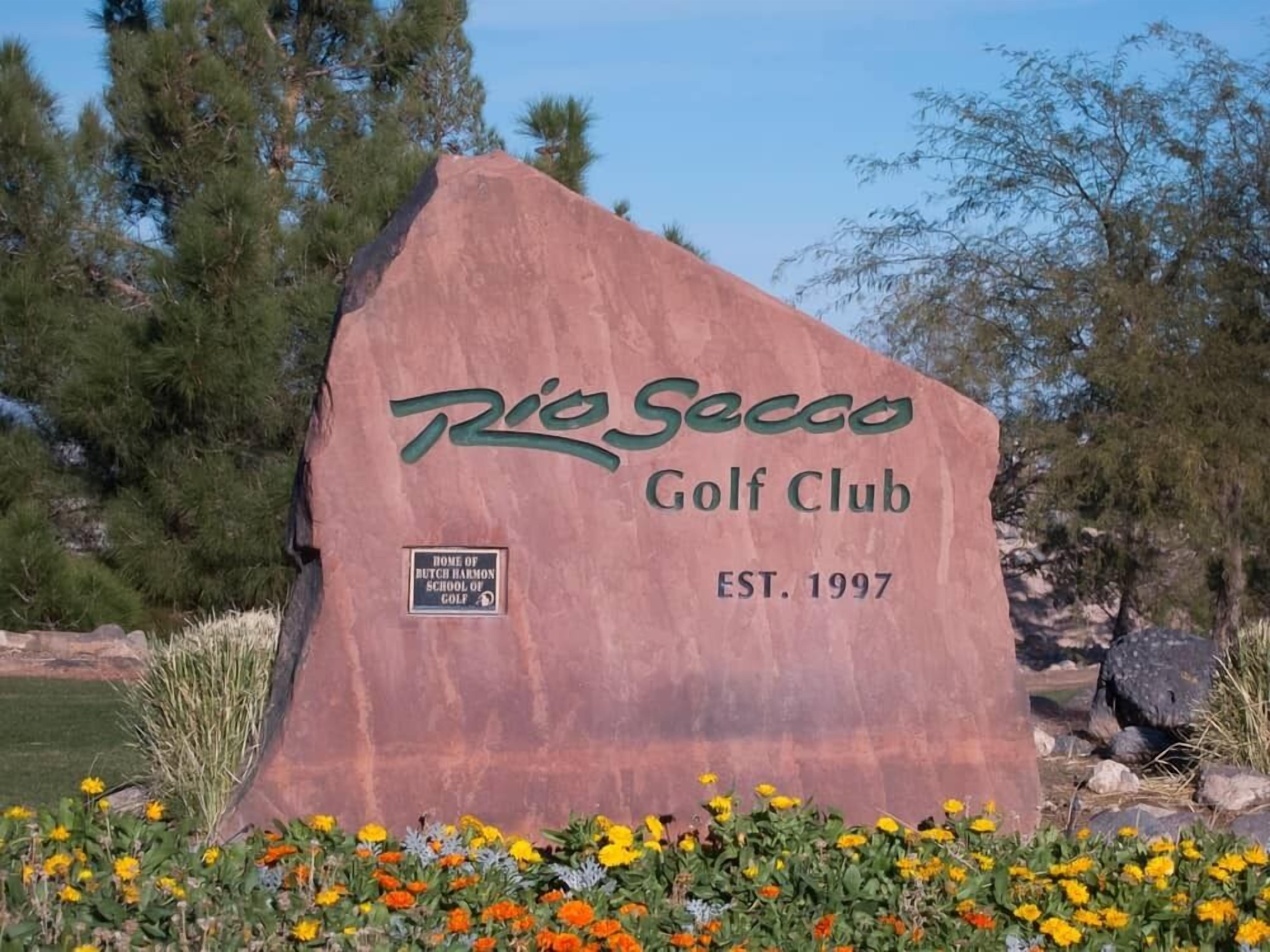 Ein großer Felsen mit dem Schriftzug "Rio Seco Golf Club GGR. 1997" und einer Plakette, die besagt: "Heimat der Butch Harmon Golfschule".